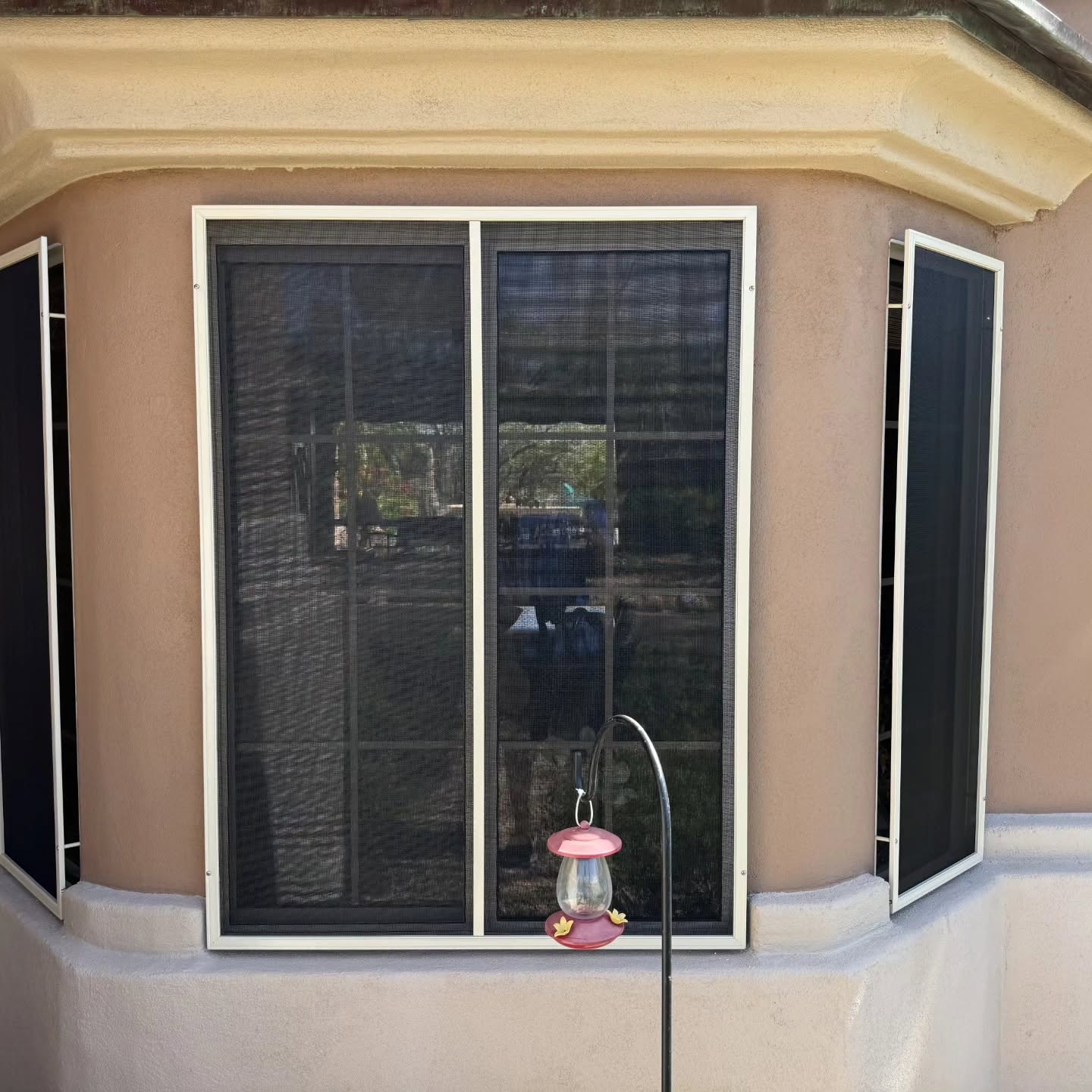 Window screens rescreened on a bay window